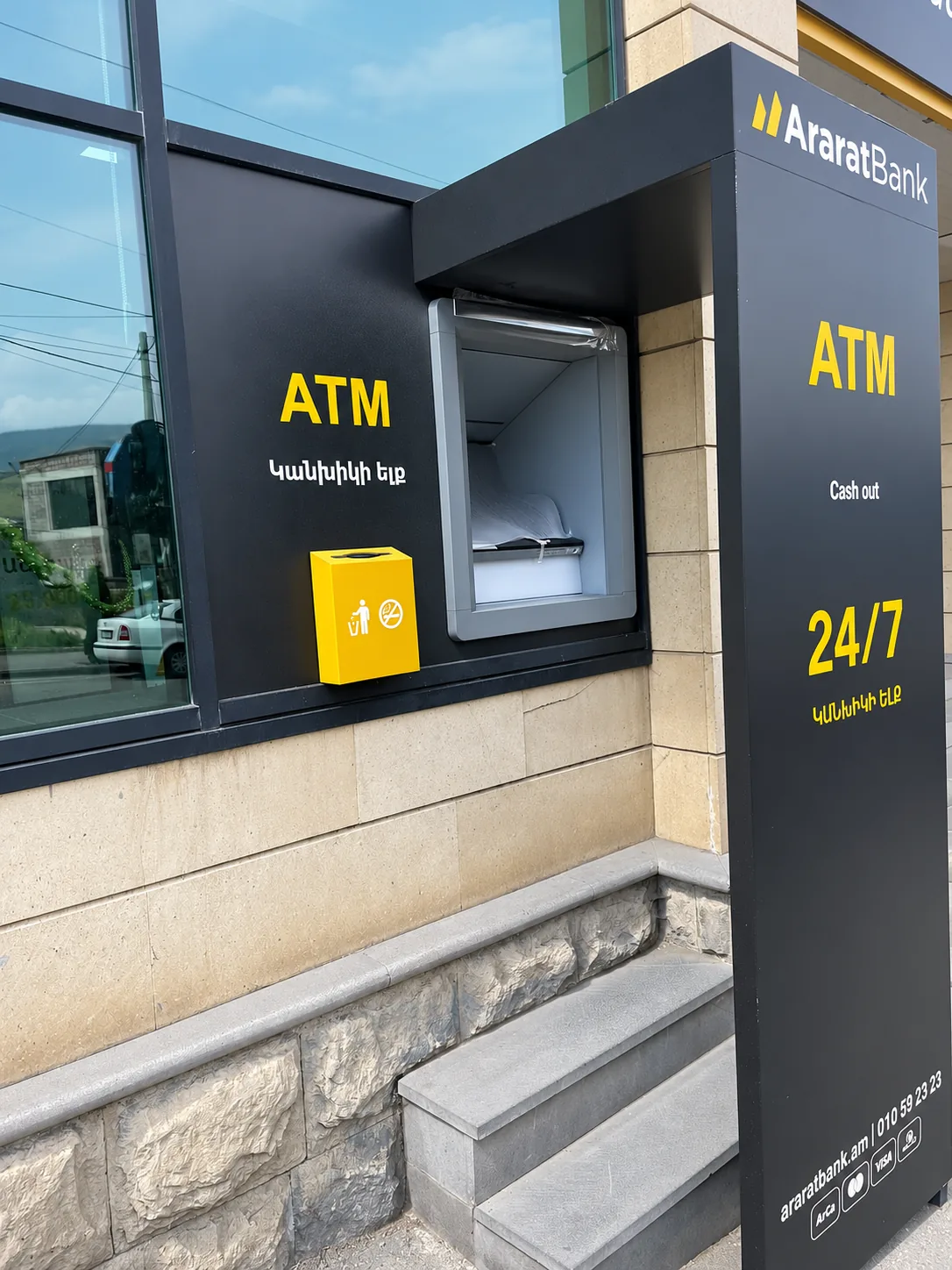 Բանկոմատի սև հովանոց քարե աստիճանների մոտ