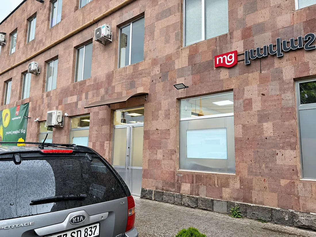 Սուպերմարկետի ցուցանակ վարդագույն քարե պատին