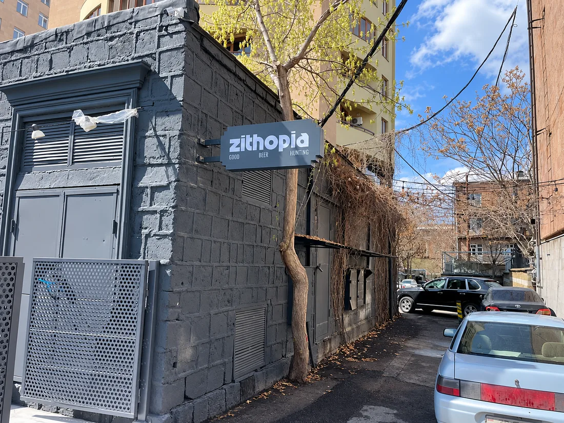 Սպիտակ տառերով ցուցանակ մայթի վերևում